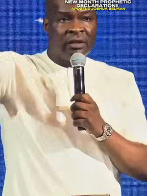 A man in off-white attire is speaking into a microphone. The background is a blurred blue pattern. Overlay text in a yellow rectangle at the top names the video and the speaker.