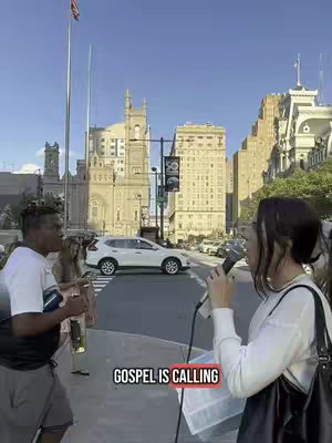 The cover image shows a street scene. A woman on the right, holding a microphone, is speaking. In front of her is a man holding a bottle and gesturing. Behind them is a white SUV crossing a street, and large buildings. The text overlayed on the image is "GOSPEL IS CALLING."