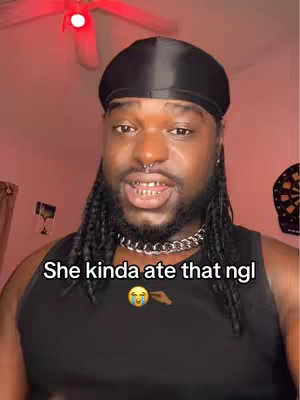 A man is shown in a close-up shot. A text overlay is at the bottom of the screen with text in white font. The man has a dark complexion, a black durag, and a silver chain. There is a red light above. The man is speaking, and his expression is animated; a tear emoji pointing to the right is displayed on the text.