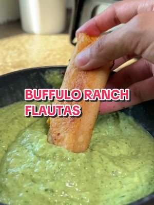 A close-up shot shows a hand dipping a rectangular flauta into a vibrant green dip. The flauta is golden brown. The dip is a creamy, textured green. The text overlay 'BUFFULO RANCH FLAUTAS' is in a bold, outlined red and white font.