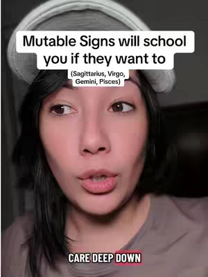 A close-up shot of a woman with dark hair wearing a beanie, looking slightly to the side with a thoughtful expression. Text overlays are present at the top and bottom of the frame. The background is blurry.
