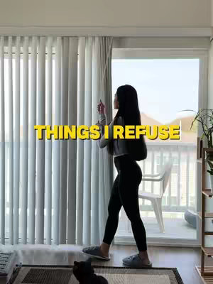A woman stands in front of a large window with vertical blinds, pulling a curtain cord. Text overlay reads 'THINGS I REFUSE'. The background includes a white chair on a balcony and a rug with a black cat on the floor.