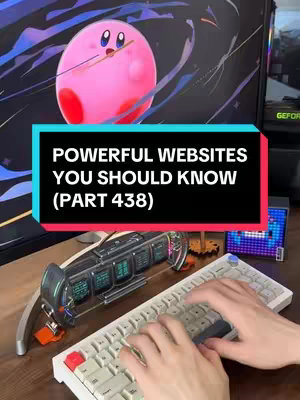The image is a vertical shot with the main focus on a keyboard being typed on. There's text overlay in a black rectangle with white text that says 'POWERFUL WEBSITES YOU SHOULD KNOW (PART 438)'. Behind it is a computer screen with an overlay of Kirby from the Kirby game series. The background includes a desk with various tech devices like a pixel display, a device with several screens, and a mechanical keyboard with red, grey and white keys.