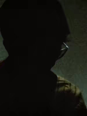 The cover image features a silhouetted figure of a person wearing glasses and a hat or cap, viewed from the side, against a dark, textured background. The image is primarily in shades of dark green and black, with the outline of the person being the most prominent visual element. The overall composition is moody and obscure due to the dark lighting and silhouette.
