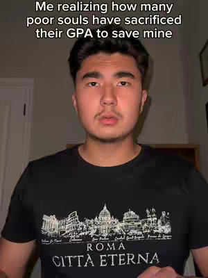 A young man with dark hair and a mustache looks directly at the camera, with text overlaid at the top. He is wearing a black t-shirt with a detailed cityscape design.