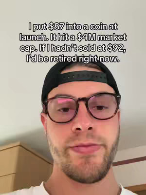 A selfie-style shot featuring a young man with a beard, glasses, and a black baseball cap. The background appears to be a neutral-colored wall. Overlayed text provides context about a cryptocurrency investment.