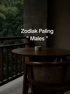 The image features a balcony setting with a dark wooden table and chair in the foreground. The focus is on the table, with a blurred background of lush green trees visible. Text overlay in white, is positioned on the upper part of the image.