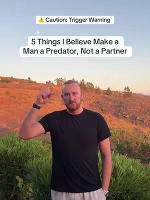 The cover image features a man standing in front of a blurred landscape with a sunset sky. The man is pointing his index finger upwards. Overlayed at the top of the image is the text in a white box, with a yellow exclamation point and “Trigger Warning” in the box. The man looks directly at the camera. The background is a blurred view of a landscape at sunset; green bushes are visible in the foreground.