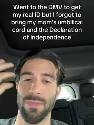 A man is sitting in a car and the camera focuses on his face. Text is overlaid on image and reads 'Went to the DMV to get my real ID but I forgot to bring my mom's umbilical cord and the Declaration of Independence'.