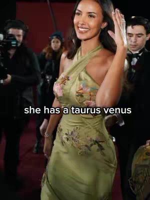 A well-lit image shows a woman in a green dress, smiling and waving. The background includes other people, suggesting a red carpet event.