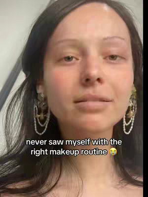 A close-up shot of a woman's face with minimal makeup, dark hair, and earrings. The woman has light skin, full lips, and is looking at the camera. Text overlay reads 'never saw myself with the right makeup routine'.
