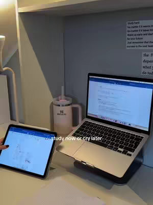 The cover image shows a desk setup with a laptop, tablet, and a water bottle. On the left, a tablet displays a document with color-coded highlighting. To the right, a laptop is propped up with a beverage container in the middle.