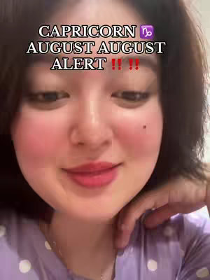 A close-up shot of a woman's face, focusing on her from the chest up. The woman has fair skin, dark hair, and is wearing a light-purple, polka-dot top. The background is blurred, suggesting a close-up perspective. Overlayed text is at the top of the screen, with two exclamation points and the word 'ALERT'. The woman's facial expression appears neutral with a slight hint of a smile.