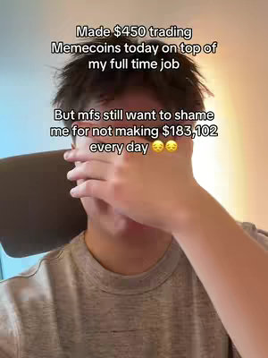 A person with dark hair is shown from the chest up, covering their eyes with one hand. Above the person, text in a white box states that the person made $450 trading memecoins on top of a full-time job, followed by a line expressing a sense of shame for not making a specific high amount of money, with two emoji reflecting sadness.