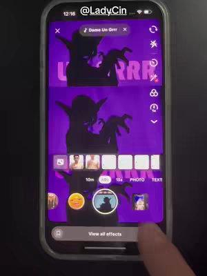 A smartphone screen is displayed, showcasing an app interface with a purple background and a Star Wars character graphic. Text overlays in a vibrant, cartoonish font read: "Dame Un Grrr". The screen is encased in a black phone frame. The user's finger is touching the screen at the bottom, interacting with icons and graphics related to the app.