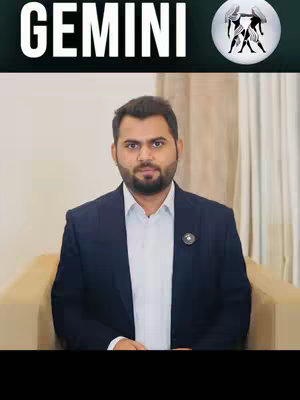A man in a navy blazer sits in front of a cream colored background. The words "GEMINI" appear in an upper banner, along with the Gemini astrological symbol in the upper right.