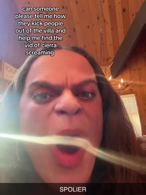 A close-up selfie of a person with long brown hair and an open mouth, expressing a strong emotion. Text overlays are present, and the background appears to be indoors.
