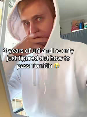 A young man wearing a white hoodie is looking at the camera with a pensive expression, his hand touching his face. Overlayed text sits at the bottom, while the interior of a home is in the background.
