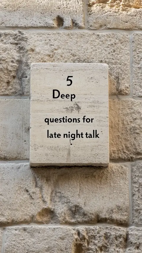 A rectangular stone tablet embedded in a textured stone wall displays text in a clean, sans-serif font. The background is a light beige stone wall with visible brick patterns and natural variations.