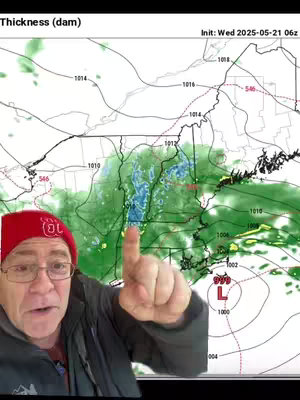 A man in a red beanie and glasses points towards a weather map, which shows isobars and areas of different types of weather.