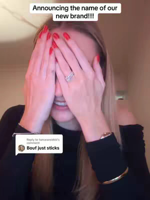 A woman with long blonde hair covers her eyes with her hands, revealing a sparkling ring on her finger. The overlay text 'Announcing the name of our new brand!!!' is displayed at the top. A comment bubble from the bottom left says 'Bouf just sticks'.