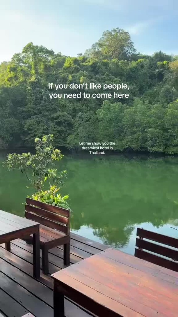 A serene outdoor scene featuring a wooden dock with tables and potted plants, overlooking a tranquil green lake surrounded by lush green trees. Text overlays suggest a peaceful hotel setting.