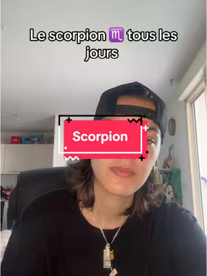 A woman in a black cap and shirt is facing the camera, with a overlaid red and white rectangle with the word "Scorpion" on it. The background is a simple room with white walls and some objects. The overall feel is personal and casual.