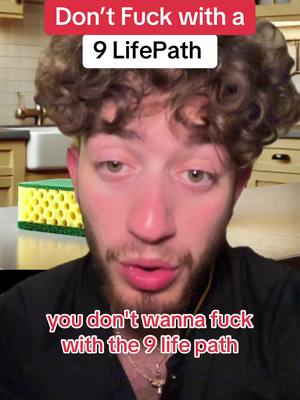 A man with curly brown hair is centered in the frame. The upper third of the image has a red banner with white text. Below the man, a banner with the same shape states a message in white text. A green and yellow sponge is visible to the left of the man in the background, in front of a kitchen setting.