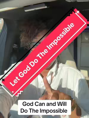 A selfie-style shot from inside a car.  A person, only partially visible from around the chest up, is wearing a white button-down shirt and glasses, with visible curly hair. A thick, slanted red banner that cuts across the image contains white text.