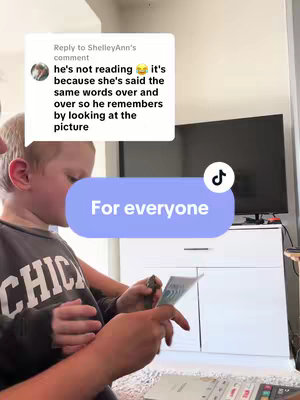 A person is holding a book and looking at it closely, while what seems to be a person is holding them. Additional text and a TikTok icon are visible.