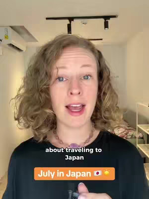 A woman with curly blonde hair looking directly at the camera with an open mouth. The text overlay reads 'July in Japan' in a bright orange rectangle with a Japanese flag and a sun icon.
