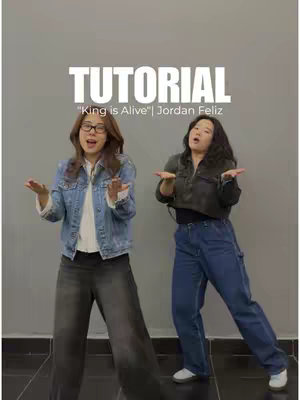 Two women with arms outstretched in a tutorial-style cover image. The woman on the left wears glasses, a denim jacket, and wide-leg gray pants. The woman on the right is in a black jacket and blue jeans. Text overlayed on the image reads “TUTORIAL” and the video title.