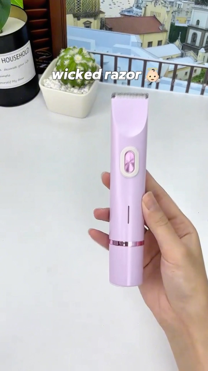 The cover image is a product shot featuring a light purple electric razor held in a person's hand. The razor is positioned vertically, with a hand gripping the lower half. The background includes a white surface, a blurry outdoor scene through a window, and a small potted plant. Text overlays read 'wicked razor' and an emoji of a baby. The overall composition is clean, with the product as the central focus, and the layout is simple.