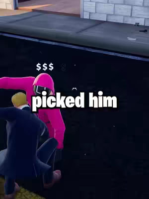 A cover image featuring a scene from the video game Fortnite. In the foreground, a figure in a pink Squid Game-style jumpsuit with a matching helmet is positioned. To the left, another figure, dressed in a suit, appears to be kneeling. Above the figure in pink, the text "picked him" is displayed in a bold, white font with a black outline. The background shows a generic in-game environment, including a section of wall.