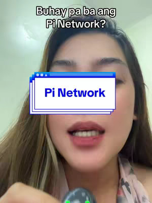 A woman with long brown hair is centered in the frame, with a subtle patterned scarf visible. Above her, the text overlay asks, 'Buhay pa ba ang Pi Network?' A blue and white graphic overlay, resembling a window with the text 'Pi Network' within, covers her lower face. She is looking at camera, with a small object in her hands.