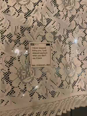 The cover image features a close-up of white lace fabric, with a small, rectangular sticky note placed on top. The note contains handwritten text in a simple, sans-serif font, centered within a white rectangle. The lace fabric has a detailed, floral pattern and creates a textured backdrop. Colors are neutral, primarily white and off-white, with soft, diffused lighting.