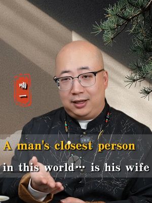 The cover image features a man wearing glasses and a black shirt with a patterned design, set against a neutral background. Text overlays on the image read, 'A man's closest person in this world... is his wife.' with Chinese characters in the corner.