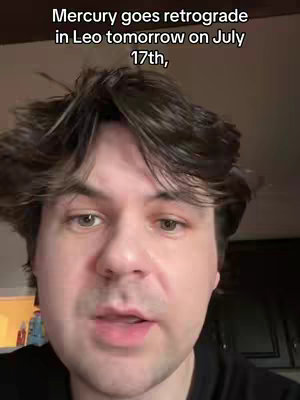 A selfie-style video thumbnail featuring a man looking at the camera from the chest up. The man has fair skin, short brown hair, and is wearing a black shirt. Text overlaid on the image reads, 'Mercury goes retrograde in Leo tomorrow on July 17th.' The background is blurred, suggesting an indoor setting.