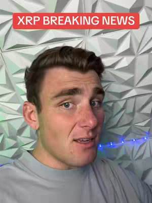 A man with brown hair looks into the camera and speaks, with a red rectangular banner over his head that reads 'XRP BREAKING NEWS'. Behind him is a white, textured wall.