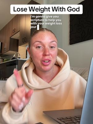 A woman in a beige hoodie is shown from the chest up, pointing her finger while speaking. Text overlays in white boxes convey the video's title and content. The background shows an apartment interior with wooden cabinets, a kitchen counter, and a window.
