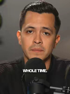 A close-up shot of a man with short, dark hair, looking up and slightly to the side. He has a neutral expression. The text, "WHOLE TIME," is overlaid in white across the bottom portion of the frame, partially obscured by the microphone in front of him.