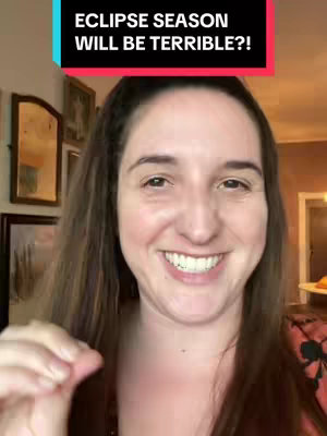 A woman with long brown hair smiles at the camera, likely in a home setting. A text overlay reads 'ECLIPSE SEASON WILL BE TERRIBLE?!' Framed behind her are framed pictures and mirrors, creating a warm background with natural lighting.