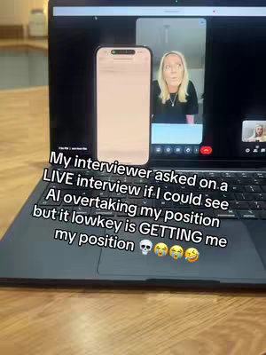 A screenshot of a laptop screen displaying a video call with a woman, overlaid with text. A phone with a blank screen is also shown, and the laptop rests on a wooden surface.