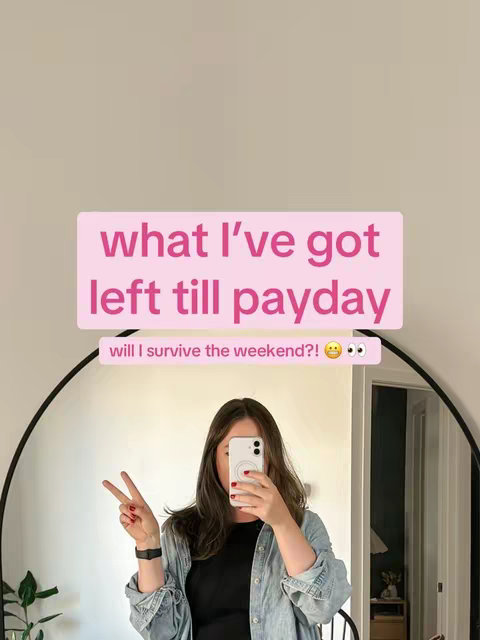 A woman is taking a selfie in front of a mirror. She is holding the phone up to her face, obscuring it. Above her head, a pink rectangle reads "what I've got left till payday." Below that, another light-colored rectangle reads "will i survive the weekend?!" with eye emojis. The background is a neutral colour. The person shows a peace symbol with their right hand. 