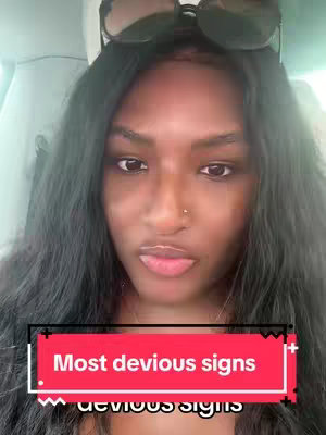 The image shows a close-up of a woman with long, dark hair and sunglasses resting on her head. She has a nose ring and a neutral expression. A text overlay at the bottom of the image reads "Most devious signs." The background appears to be inside a vehicle.