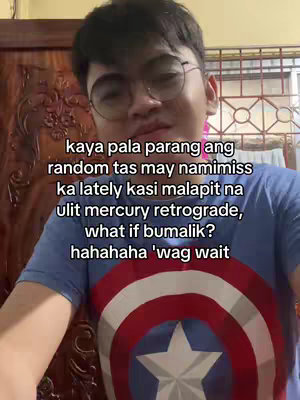 A selfie-style video cover image featuring a young man with glasses. He is positioned from the chest up, with his face centered. The background includes a wooden cabinet and a window. The man is wearing a navy blue shirt that has a Captain America shield in the chest area. Text overlayed on the image provides the video's hook.