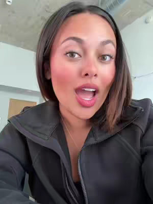 The cover image features a young woman with brown hair and a black zip-up jacket against a neutral background. She has a surprised expression, with her mouth open and eyes wide as if she's reacting to something. Her cheeks are flushed with bright pink blush, and she has lipstick. The lighting is soft and even, suggesting an indoor setting, possibly with natural light. The overall composition is a close-up, drawing attention to her face and expression.