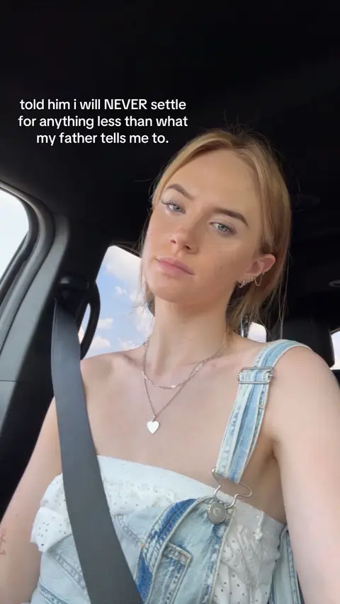 A woman with blonde hair and light eyes is inside a car. She is wearing a light-colored top, and a seatbelt is across her. Text overlaid on the image says: "told him i will NEVER settle for anything less than what my father tells me to."