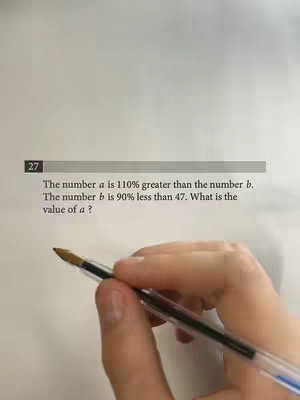 A hand holding a pen is pointing at a math problem on a piece of paper. The paper has a problem written on it, and a gray box with the number 27 is in the left corner.