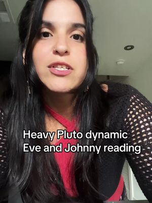 A woman with long, dark hair is shown in a medium shot, facing the camera. She wears a red top and a black, open-knit cardigan. Overlayed text at the bottom reads, 'Heavy Pluto dynamic Eve and Johnny reading'. The background is a neutral, indoor setting.